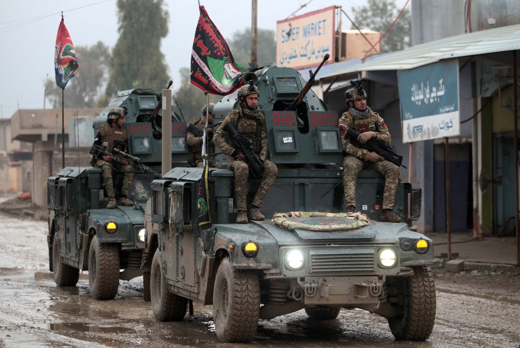 Iraqi pro-government forces patrol the eastern part of the embattled Iraqi city of Mosul on December 28, 2016, during an ongoing military operation against Islamic State (IS) group jihadists. / AFP.