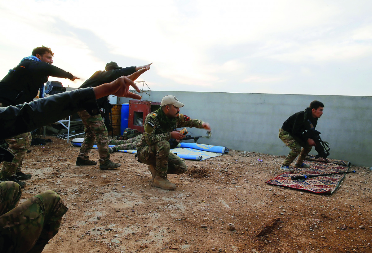 Iraqi security forces take cover during clashes with IS militants, north of Mosul, Iraq, yesterday.