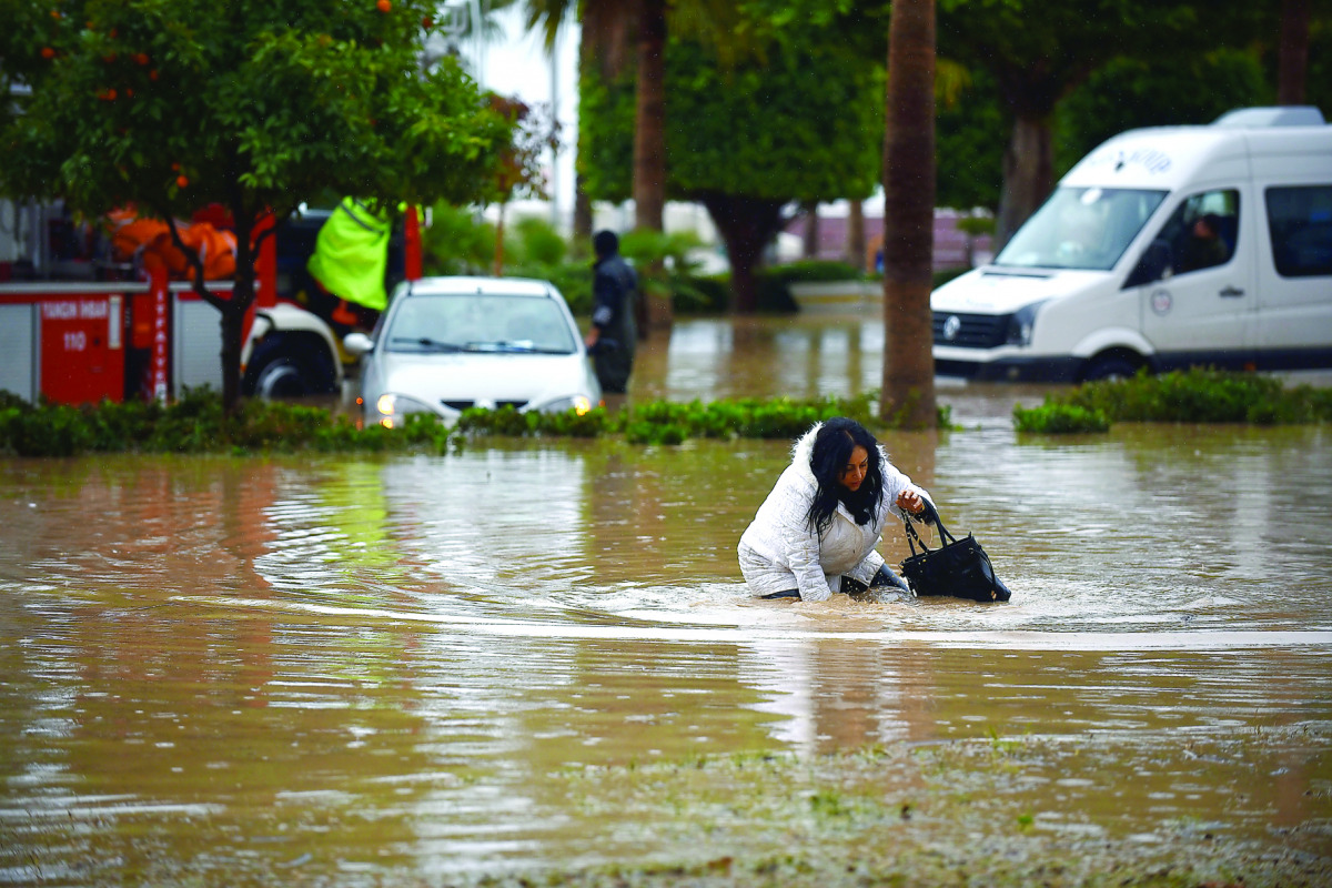 A woman wades through floodwater after a heavy rainfall hit Mersin, Turkey, yesterday.