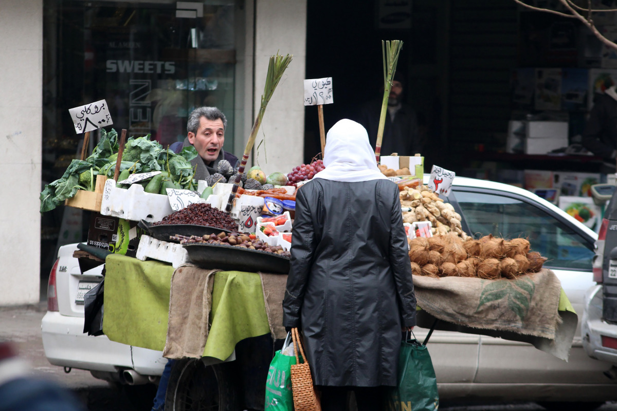 A Syrian woman shops for vegetables for in Aleppo's government controlled Al-Jamiliyah neighbourhood on December 31, 2016. / AFP / George OURFALIAN