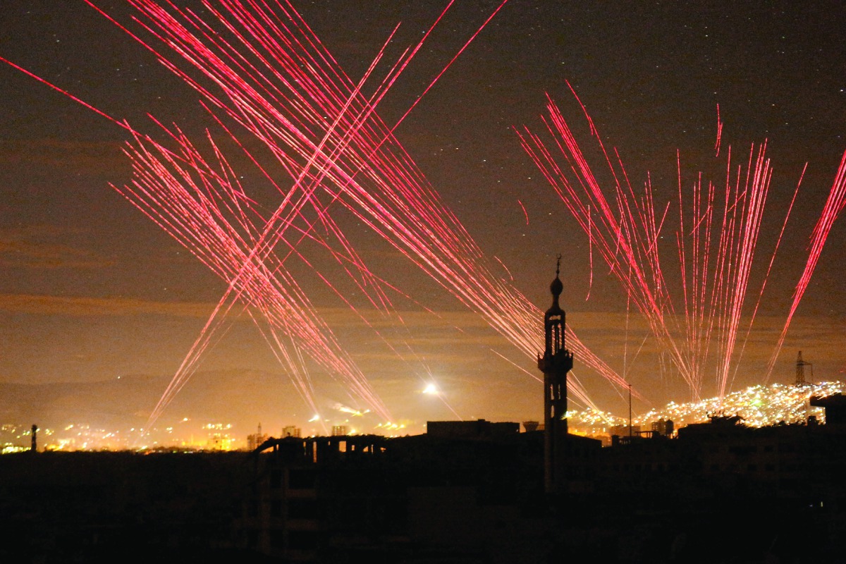 Lights illuminate the sky after regime forces fire into the air during New Year’s celebrations in Damascus, Syria.