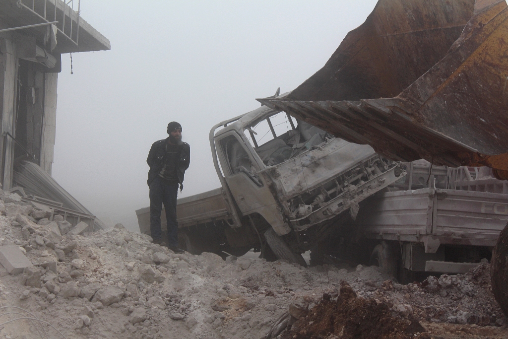 A man inspects the area after warcrafts belonging to Assad Regime forces attacked with vacuum bomb to Etarib district of Aleppo, Syria on January 1, 2017.  Ahmed al Ahmed - Anadolu Agency 
