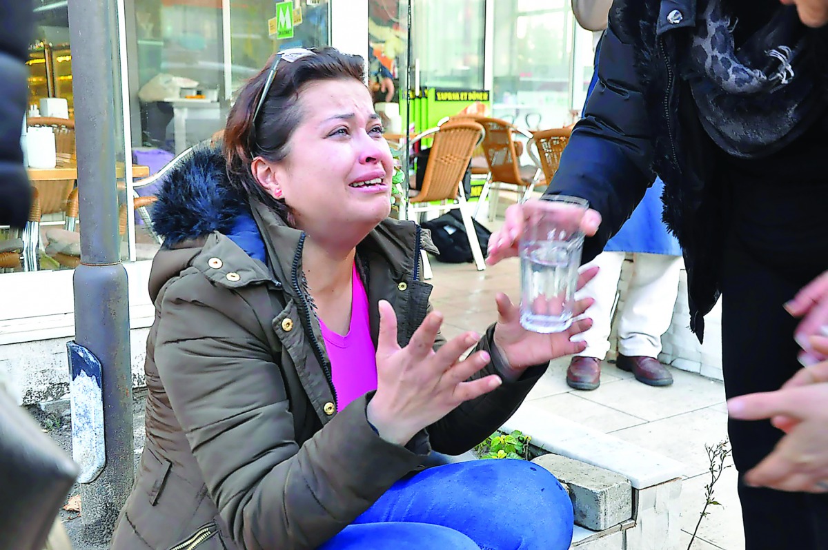 A woman reacts as she is given a glass of water near the scene of a car bomb outside the courthouse in Izmir, yesterday.