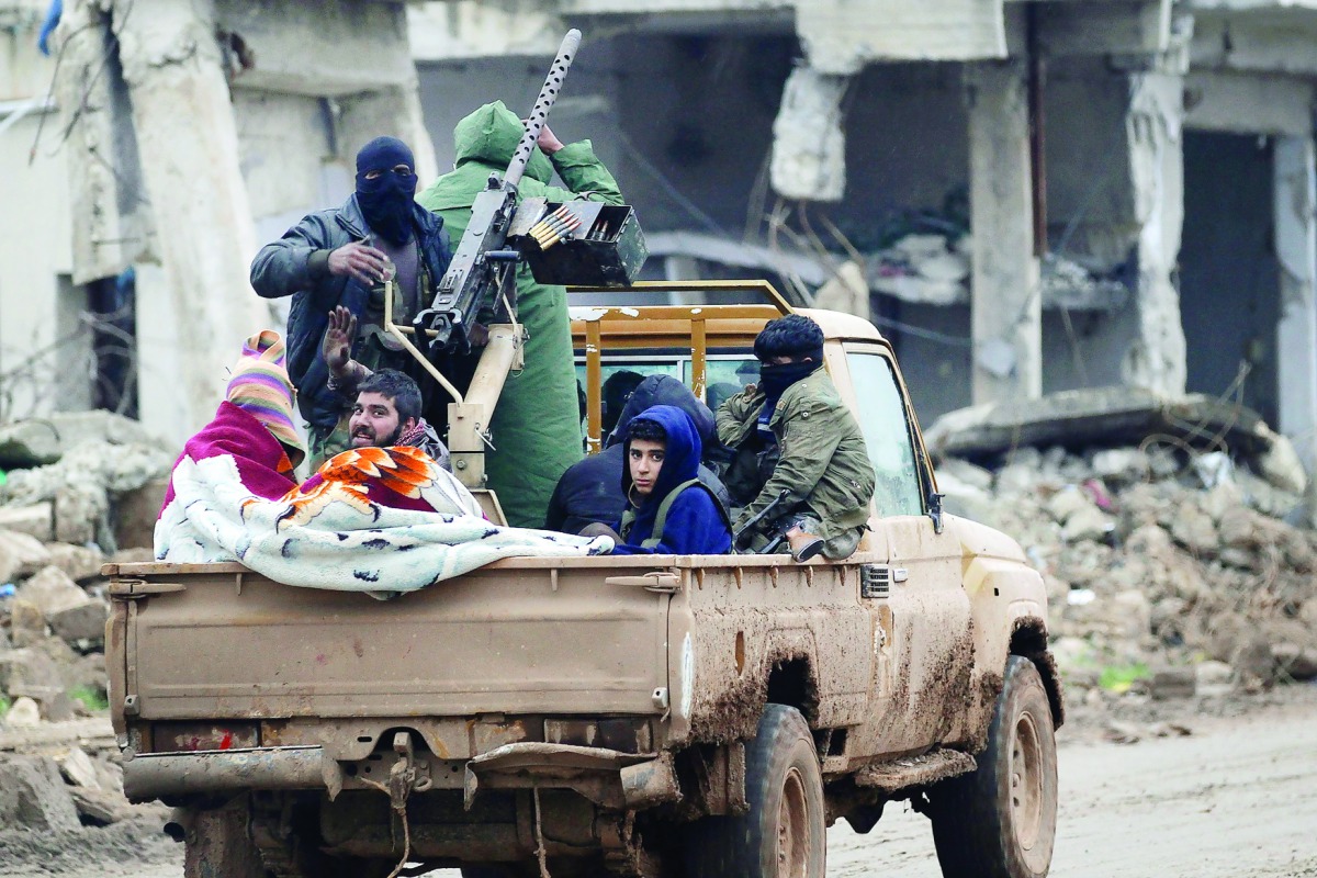 Rebel fighters ride on a pick-up truck in the northern Syrian rebel-held town of Al Rai, yesterday.