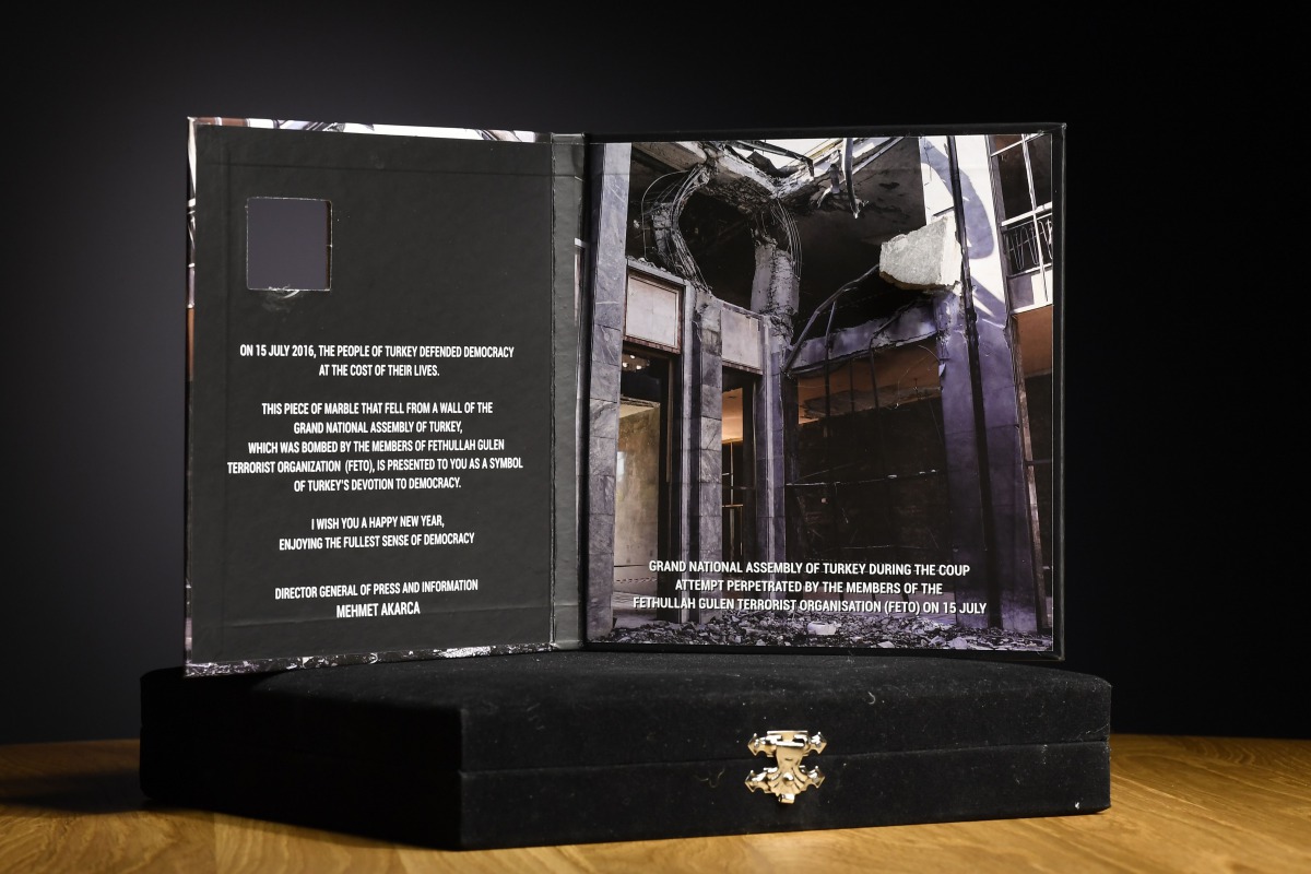 A photo taken on January 6, 2017 in Paris shows Turkey's New Year's card, signed by its Director General of Press and Information Mehmet Akarca and addressed to the foreign press, diplomats and Turkish officials, containing a fragment of the parliament bu