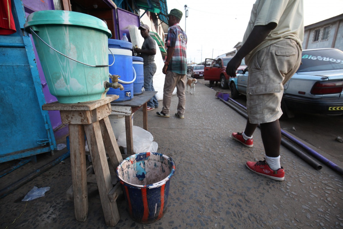 A chlorinated water bucket to help curb the spread of Ebola virus is placed on a street corner in downtown Monrovia, Liberia, April 1, 2016 (EPA / AHMED JALLANZO) 