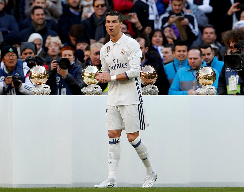 Real Madrid's Cristiano Ronaldo poses with his 4th Ballon d'Or (Golden Ball) before their Spanish first division soccer match against Granada. REUTERS/Juan Medina

