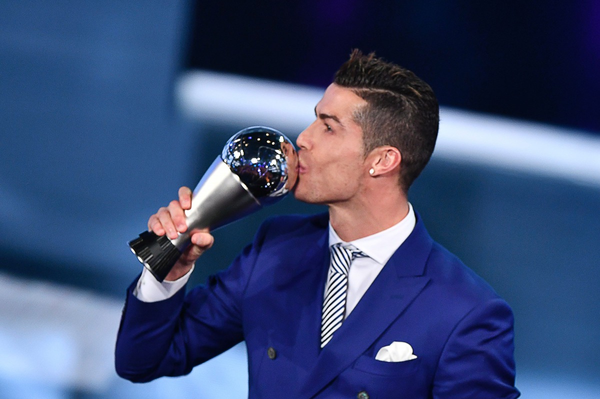 Real Madrid and Portugal's forward Cristiano Ronaldo kisses his trophy after winning the The Best FIFA Men?s Player of 2016 Award next to FIFA president Gianni Infantino during The Best FIFA Football Awards ceremony, on January 9, 2017 in Zurich. (AFP / F