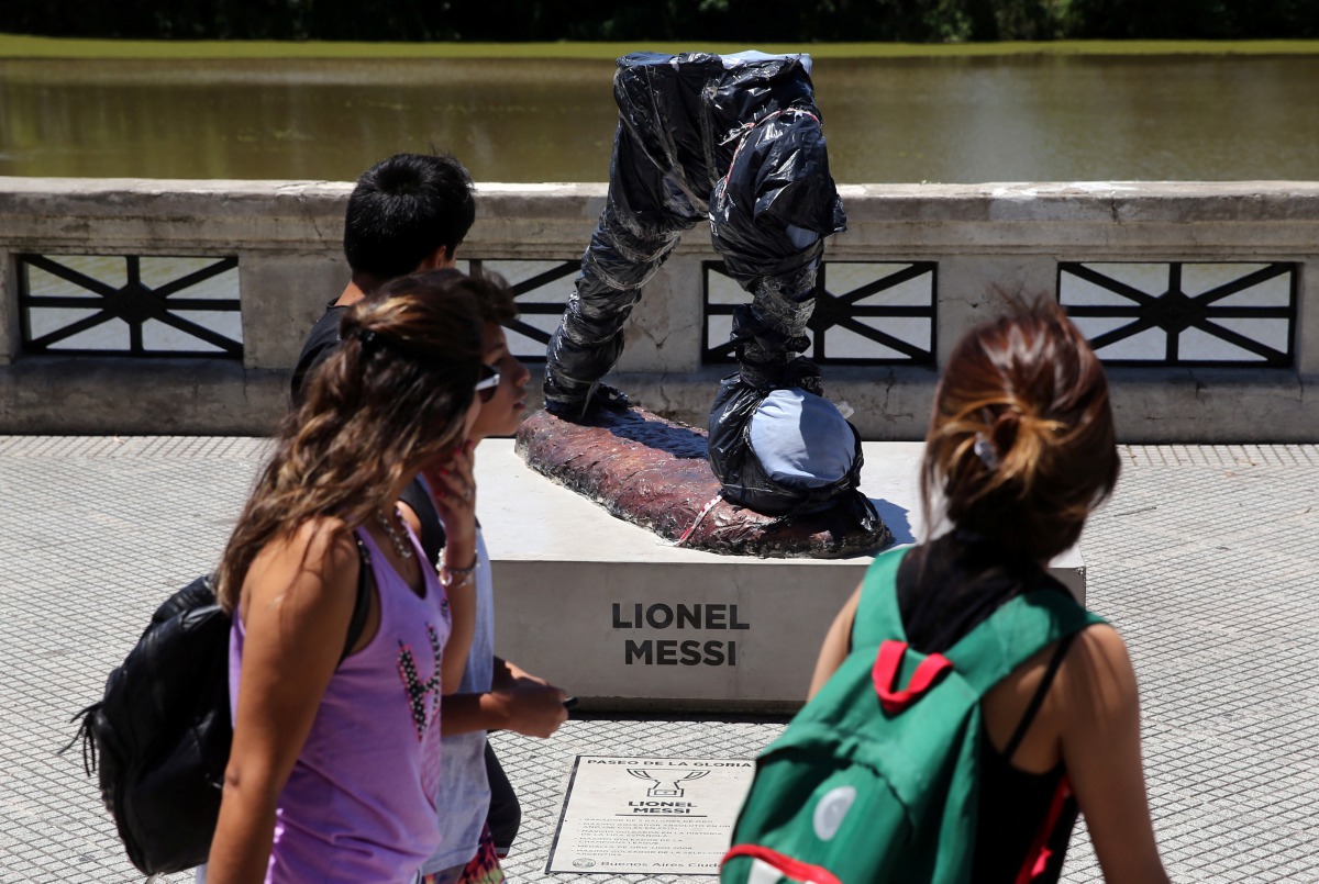 People walk past the statue of Argentina's soccer player Lionel Messi after it was vandalized in Buenos Aires, Argentina, January 10, 2017. REUTERS/Marcos Brindicci