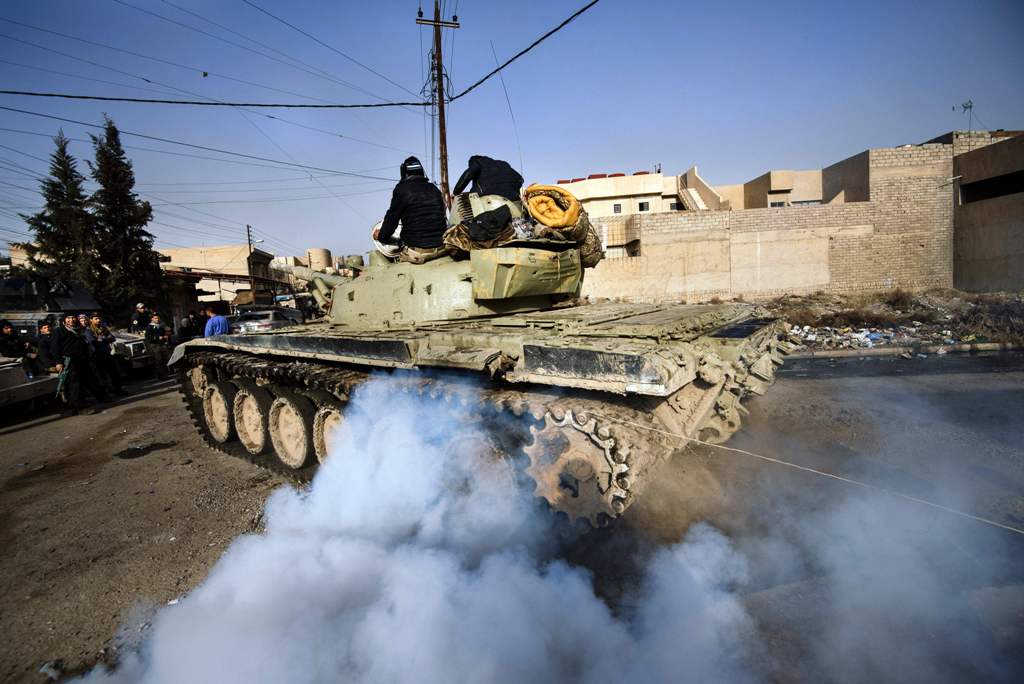 An Iraqi army T-72 tank heads to the frontline during a battle against the Islamic State (IS) group near the Fourth Bridge over the Tigris River connecting eastern and western Mosul on January 10, 2017. AFP / Dimitar DILKOFF