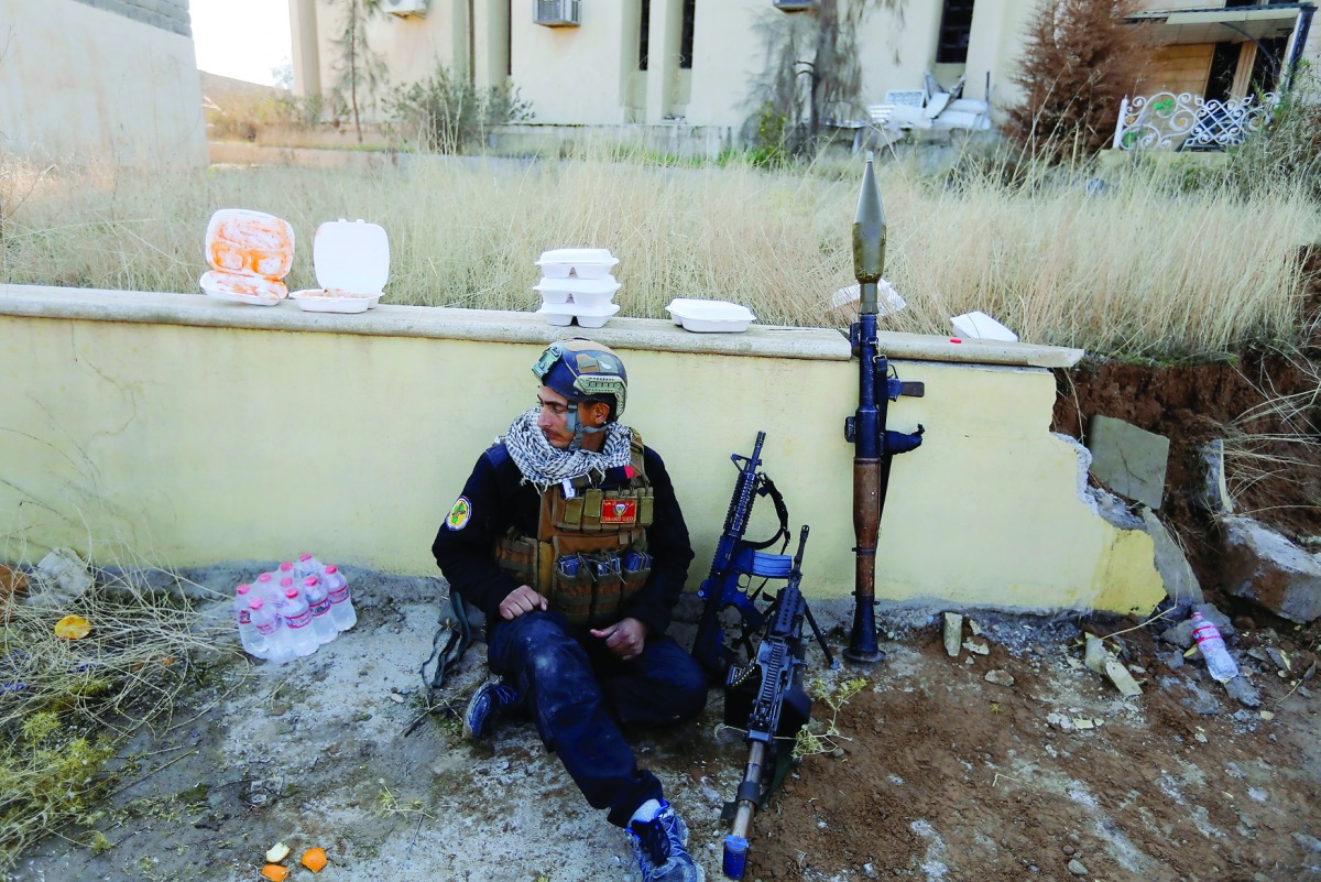 A member of Iraqi Special Operations Forces (ISOF) rests at the University of Mosul during a battle with Islamic State militants, in Mosul, Iraq, yesterday.
