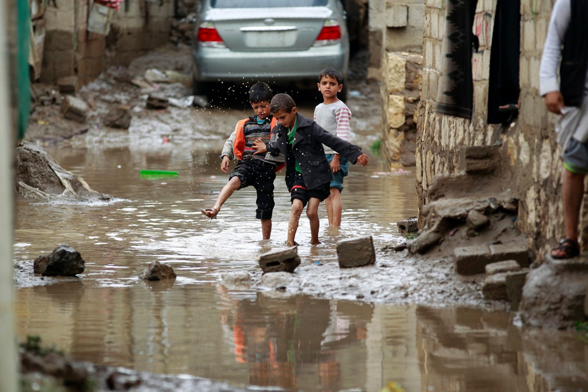 FILE PHOTO: Yemeni children play in water puddles following heavy rainfall in the outskirts of the Yemeni capital, Sanaa on July 31, 2016 (AFP / MOHAMMED HUWAIS) 