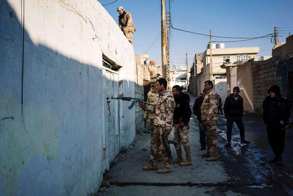 A demining expert from the Iraqi army points his weapon towards a locked door as he searches for booby-trapped buildings in eastern Mosul on January 16, 2017, during an ongoing military operation against Islamic State (IS) group jihadists.  AFP / Dimitar 