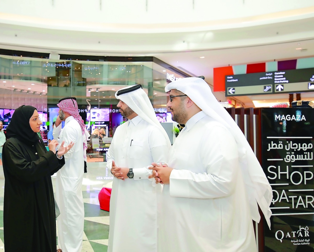 Hassan Al Ibrahim, QTA’s Chief Tourism Development Officer (right); Abdulaziz bin Nasser Al-Khalifa, CEO of Qatar Development Bank (second right), and Mashal Shahbik, QTA's Festivals and Tourism Events Director, during a tour of the pop-up shops at Mall o