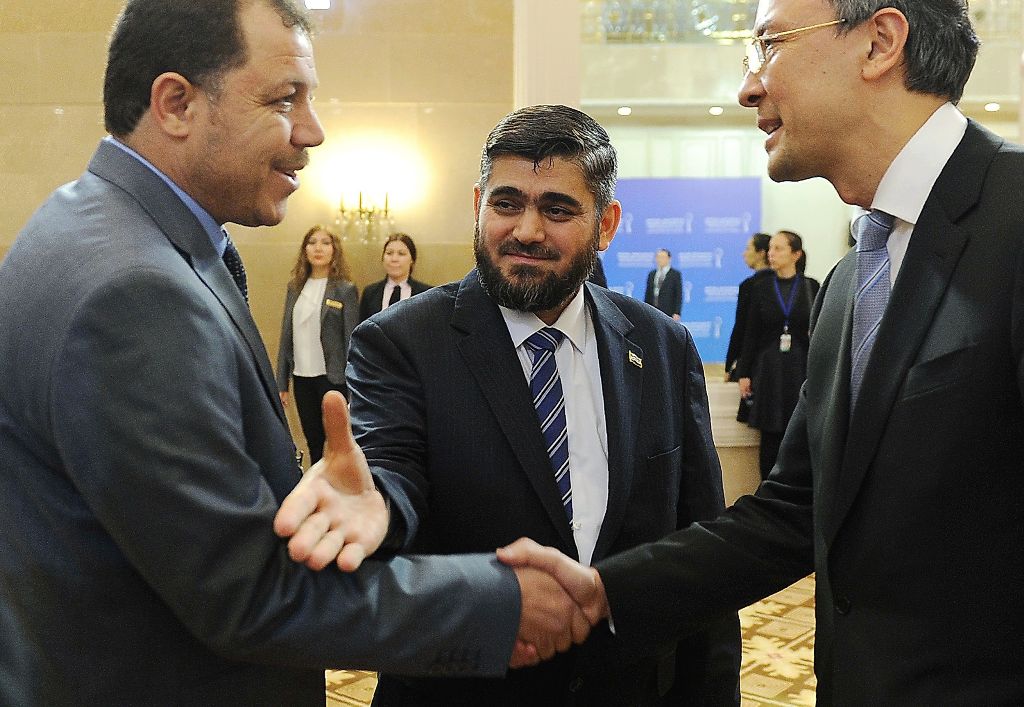 Chief opposition negotiator Mohammad Alloush (C) of the Jaish al-Islam (Army of Islam) rebel group arrives to attend the first session of Syria peace talks at Astana's Rixos President Hotel on January 23, 2017. / AFP / Ilyas Omarov
