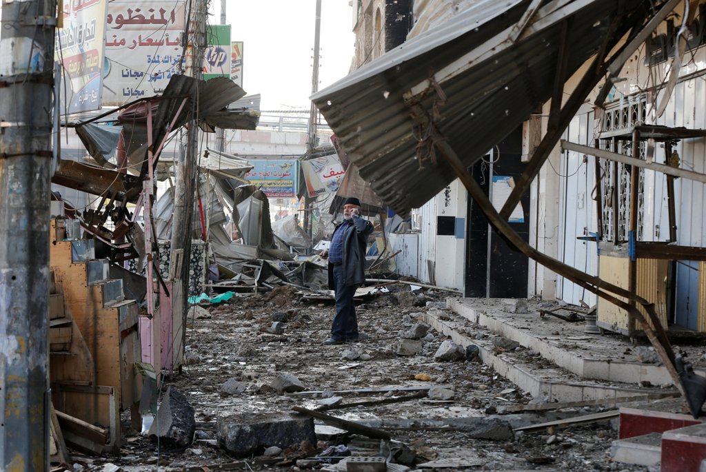A man speaks on his phone next to destroyed houses at al Zohour area in Mosul, Iraq, January 23, 2017. REUTERS/Muhammad Hamed
