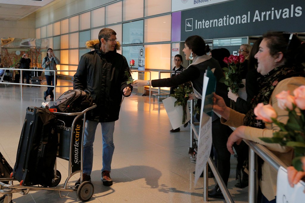 Laura Atlas Kravitz, an opponent of US President Donald Trump's executive order travel ban, hands a flower to an arriving international traveler at Logan Airport in Boston, Massachusetts, US February 3, 2017. Reuters/Brian Snyder