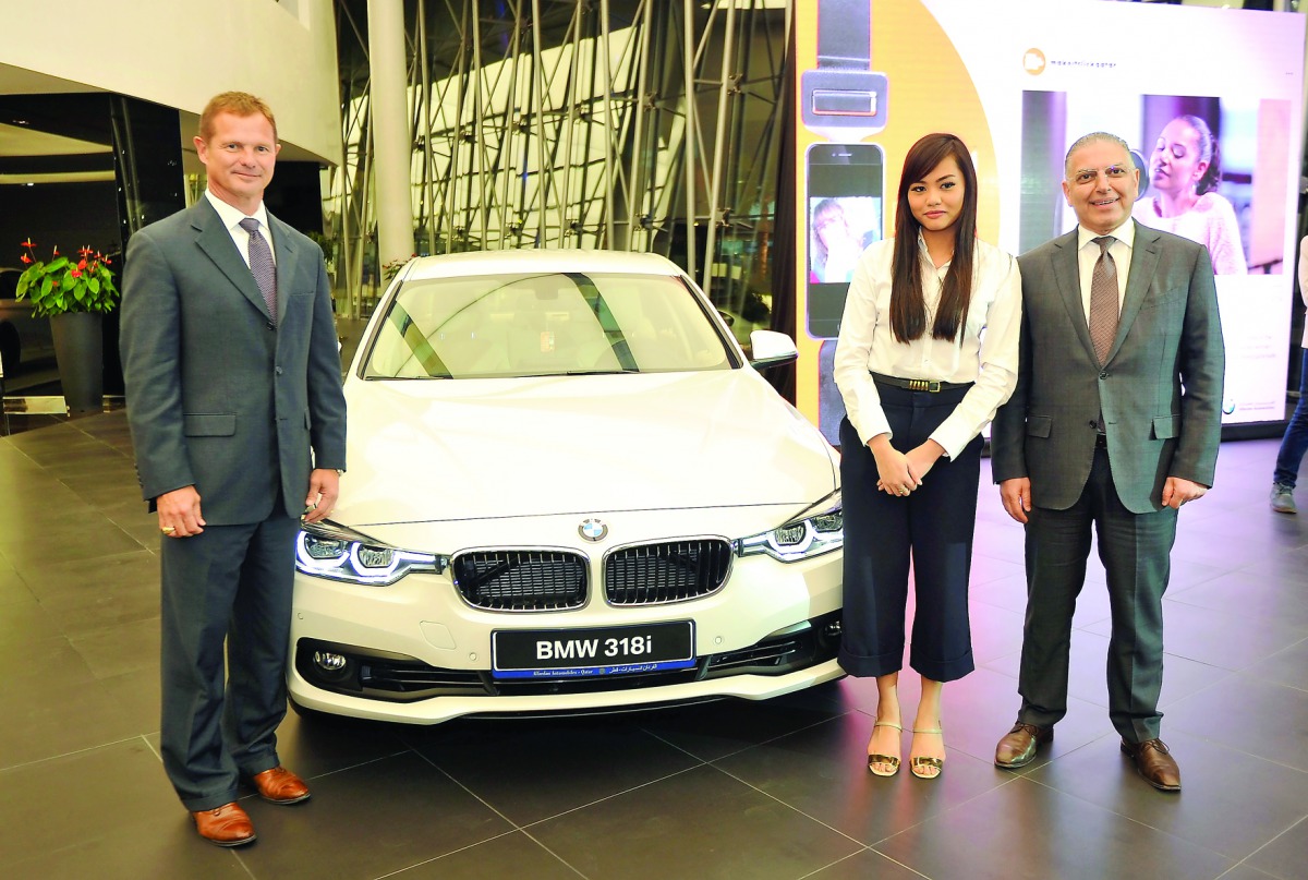 Todd Creege, President ConocoPhillips (left), and Ihab Allam, General Manager of BMW (right) with Rona Salazar the winner of #MakeItClickQatar at BMW showroom West Bay. Pic: Abdul Basit / The Peninsula