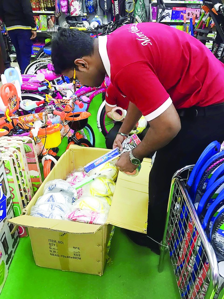 An employee at a sports shop in Doha displays newly arrived equipment.