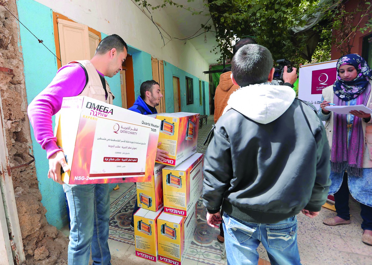 Representatives of Qatar Charity distributing lighting units to the citizens of Gaza.