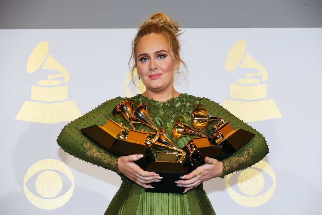 Adele holds the five Grammys she won including Record of the Year for 
