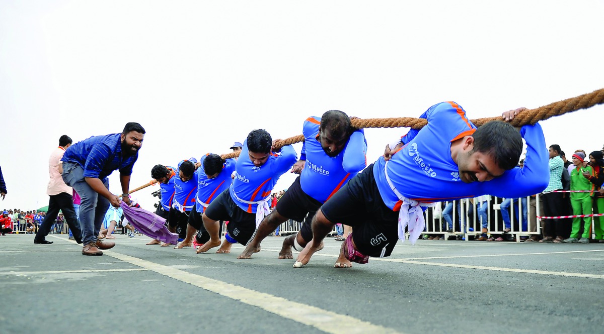Workers participate in the tug-of-war at Asian Town yesterday. 