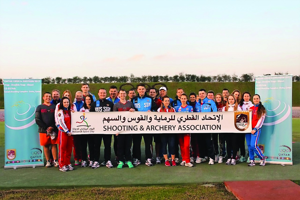 Participants of the Qatar Open Shotgun Championship hold a banner during National Sport Day celebrations at the Losail Shooting Complex on Tuesday. Around 300 shooters from 32 countries - including world champions and Olympic medal winners - are in action