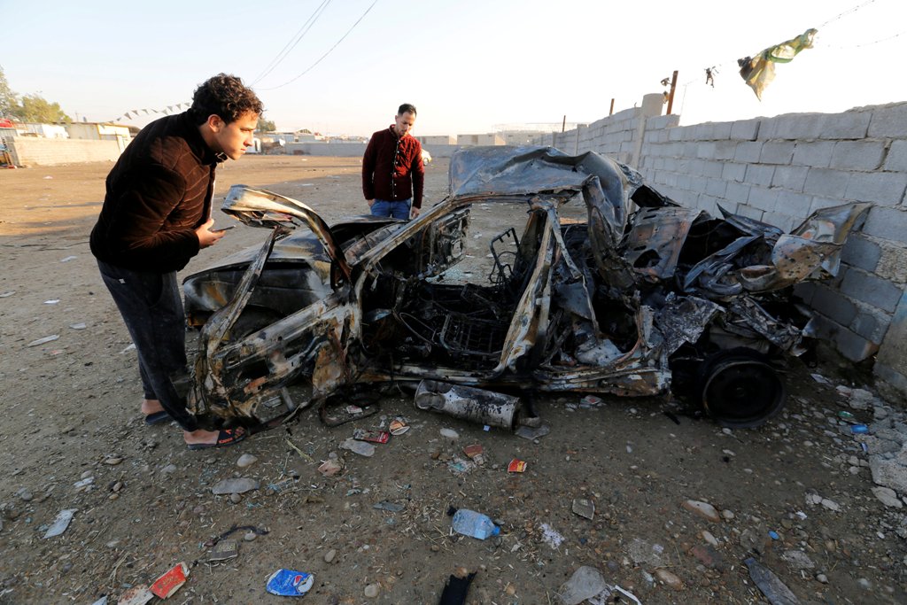 Men look at the wreckage of a burnt car after a suicide bomber detonated a pick-up truck on Wednesday in Sadr City, a heavily populated poor Shi'ite suburb of Baghdad, Iraq, February 16, 2017. REUTERS/Wissm al-Okili