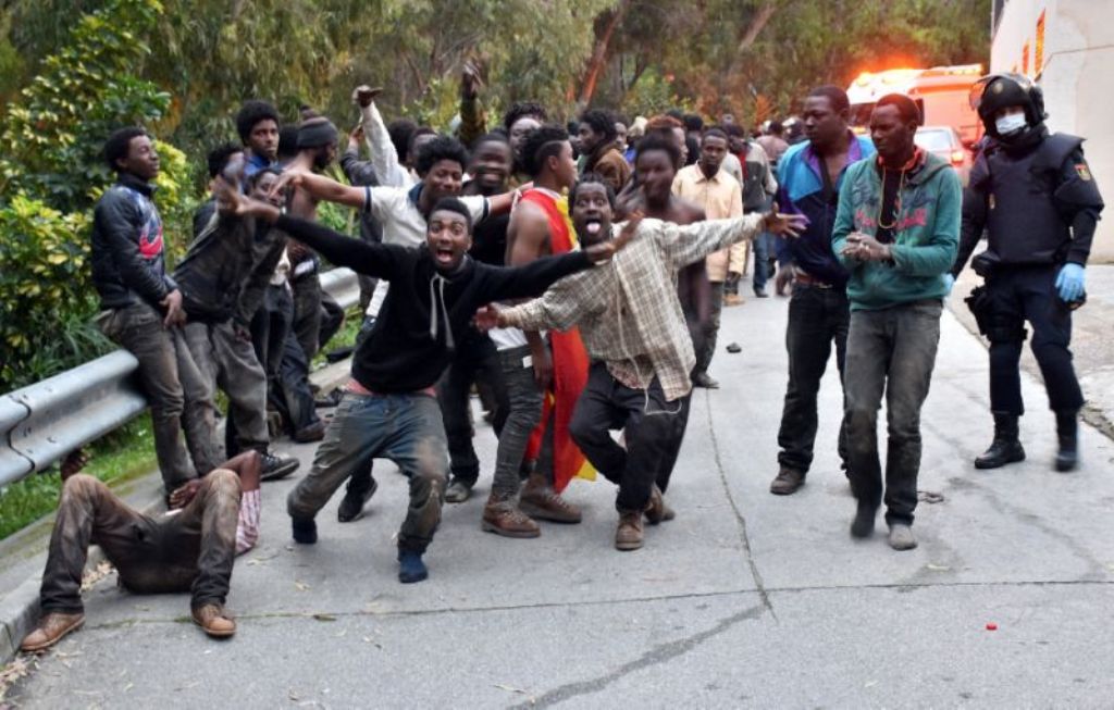 Migrants celebrate outside the Center for Temporary Stay of Immigrants (CETI) after forcing their way through fence between Morocco and Spanish enclave of Ceuta, on February 17, 2017 (AFP Photo/Antonio Sempere).