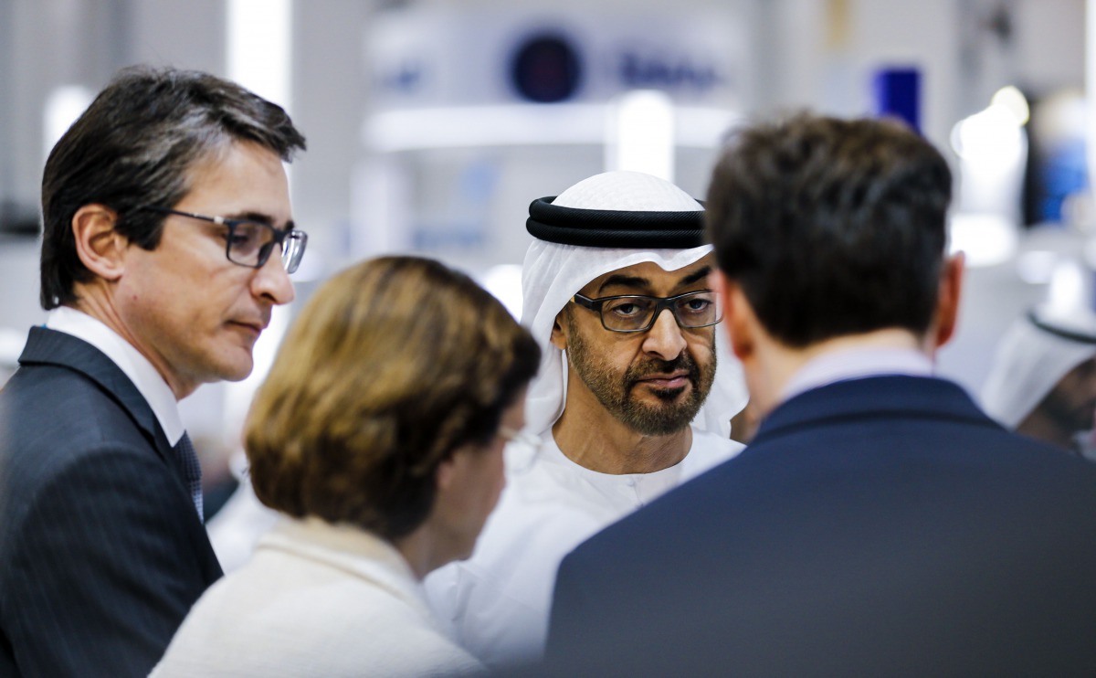 Crown Prince of Abu Dhabi Sheikh Mohammed bin Zayed al-Nahyan (C) stands next to Patrice Caine (L), CEO of French multinational company Thales, in a showroom during the opening of the International Defence Exhibition and Conference (IDEX) in the Emirati c