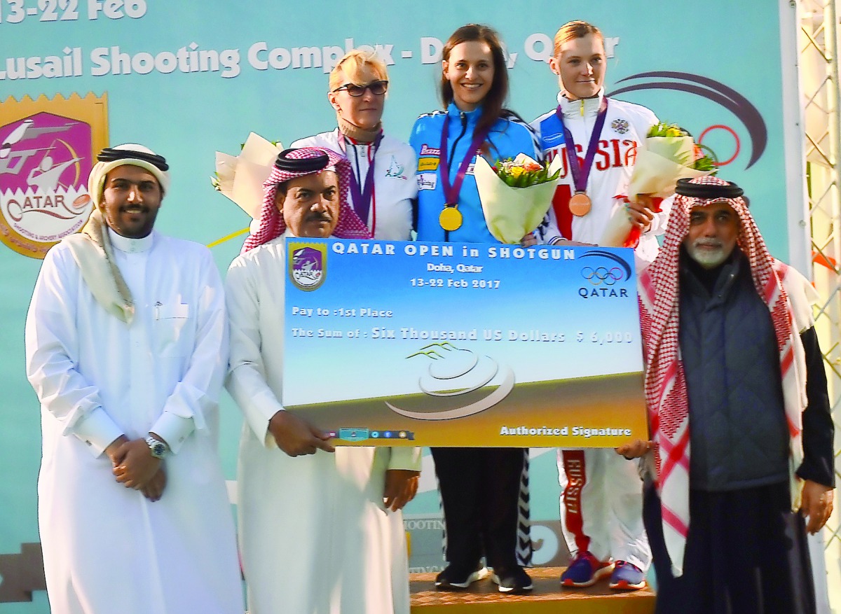 Danka Bartekova (centre) of Slovakia, winner of the skeet title at the Qatar Total Open, celebrates on the podium at the Losail Shooting Range, after receiving the winner's cheque from Qatar Shooting and Archery Association (QSAA) General Secretary Ahmed 