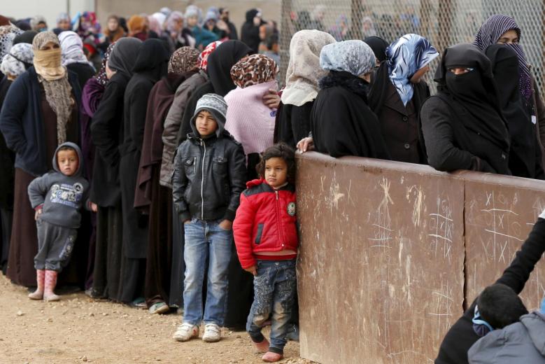 File photo of Syrian refugees as they wait for aid packages at Al Zaatari refugee camp. Reuters 