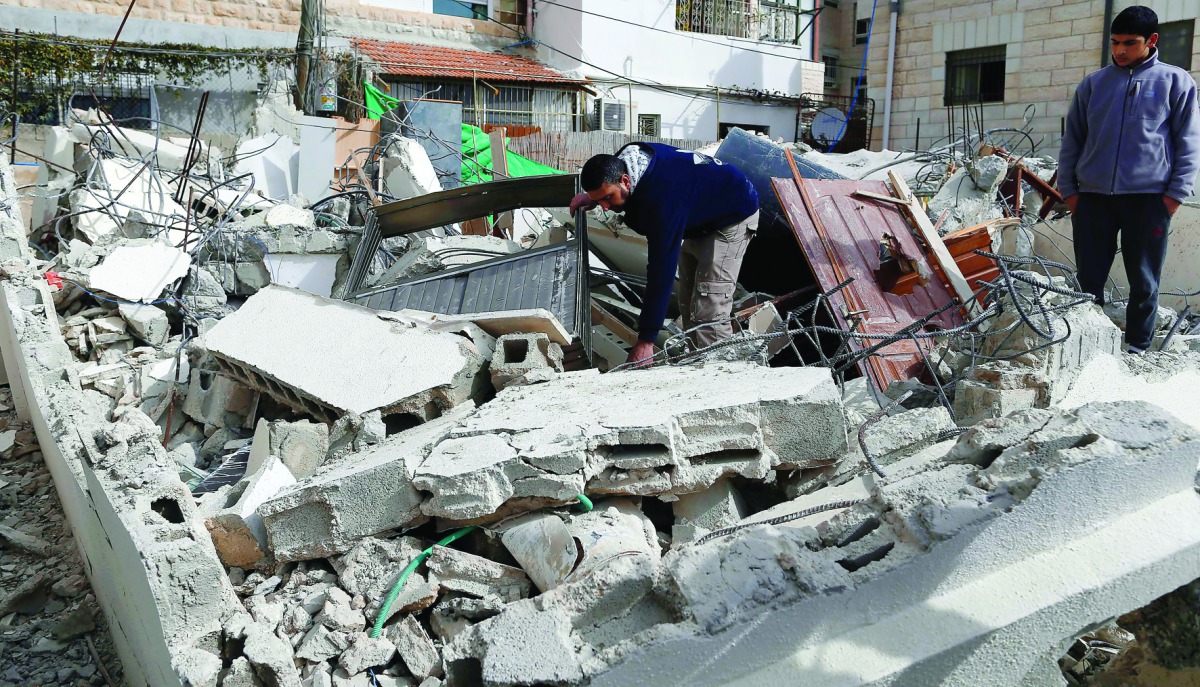A Palestinian man from the Abu Ramouz family gathers his belongings outside his house that was demolished by Israeli army bulldozers in the Arab east Jerusalem neighbourhood of Beit Hanina, yesterday.