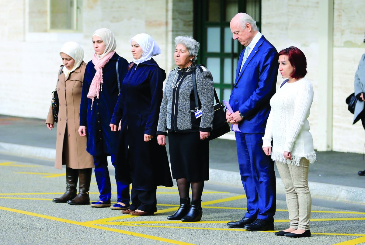 United Nations mediator for Syria Staffan de Mistura and a group of women whose family members have either been detained by Syrian authorities or abducted by armed groups, hold a minute of silence, outside the United Nations office in Geneva during the Ge