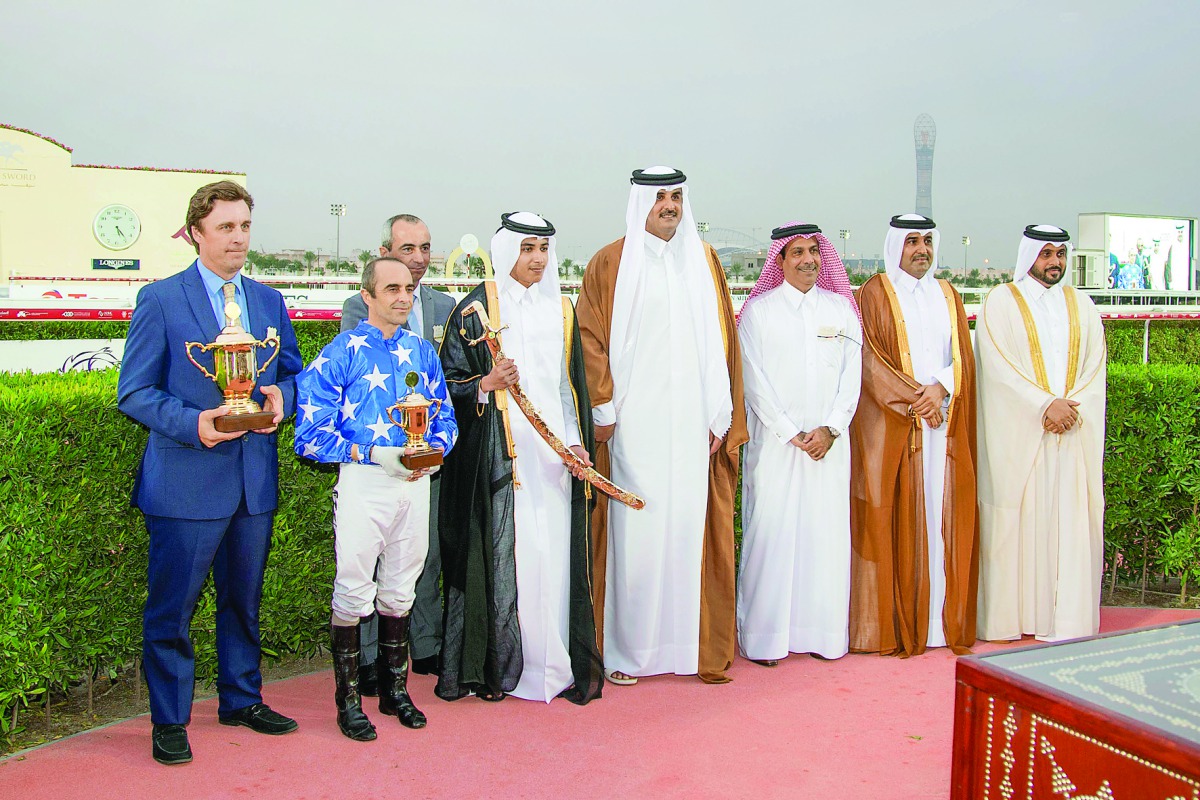 The winning team of Ebraz consisting of British jockey Alan Munro, American trainer Julian Smart and owner H E Sheikh Mohammed bin Khalifa Al Thani, pose for a picture with Emir HH Sheikh Tamim bin Hamad Al Thani, during the award ceremony of the Emir’s S