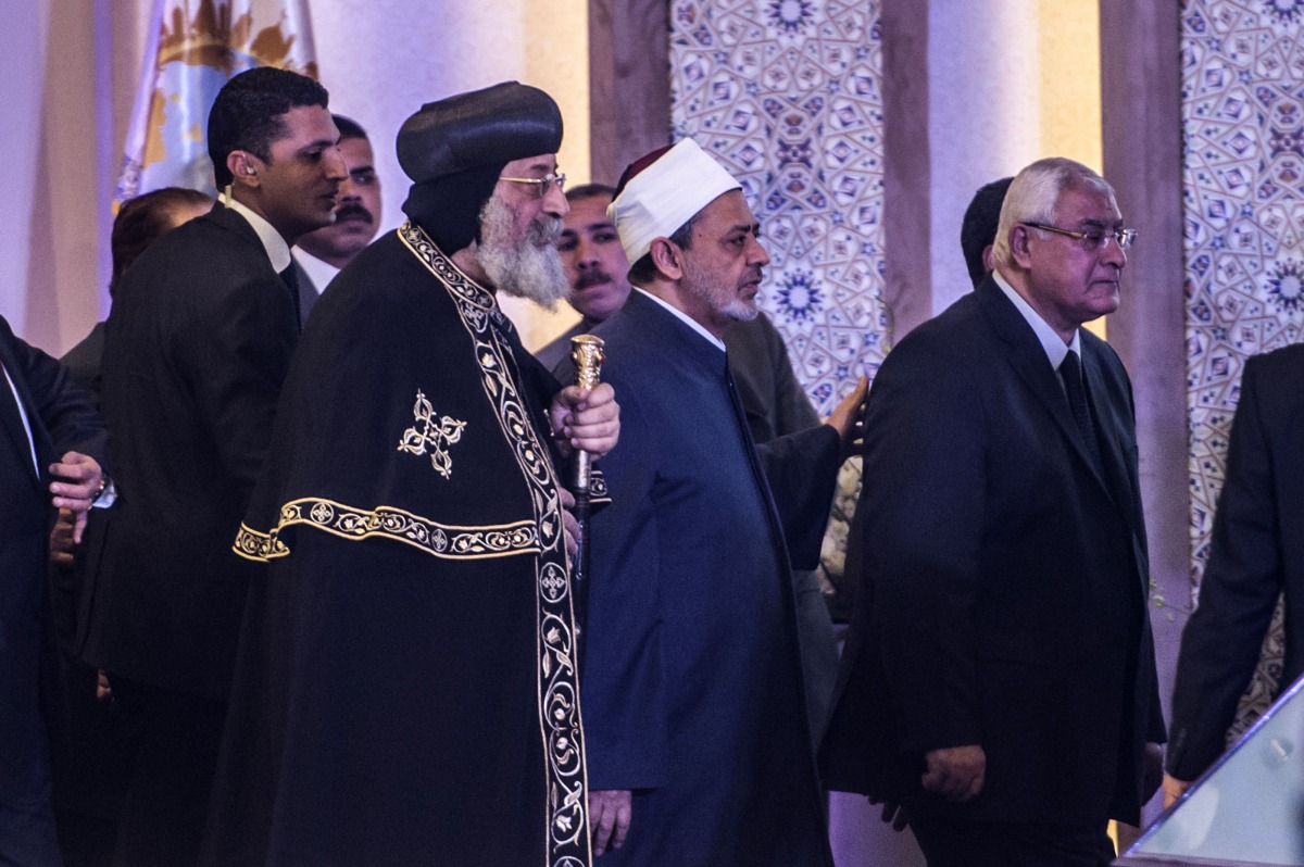 Egypt's Grand Imam of al-Azhar Sheikh Ahmed Mohamed al-Tayeb (C) Egypt’s former interim president Adly Mansour (R), and Leader of Egypt's Coptic Church, Pope Tawadros II (L) of Alexandria arrive to attend a conference titled “Freedom and citizenship” host