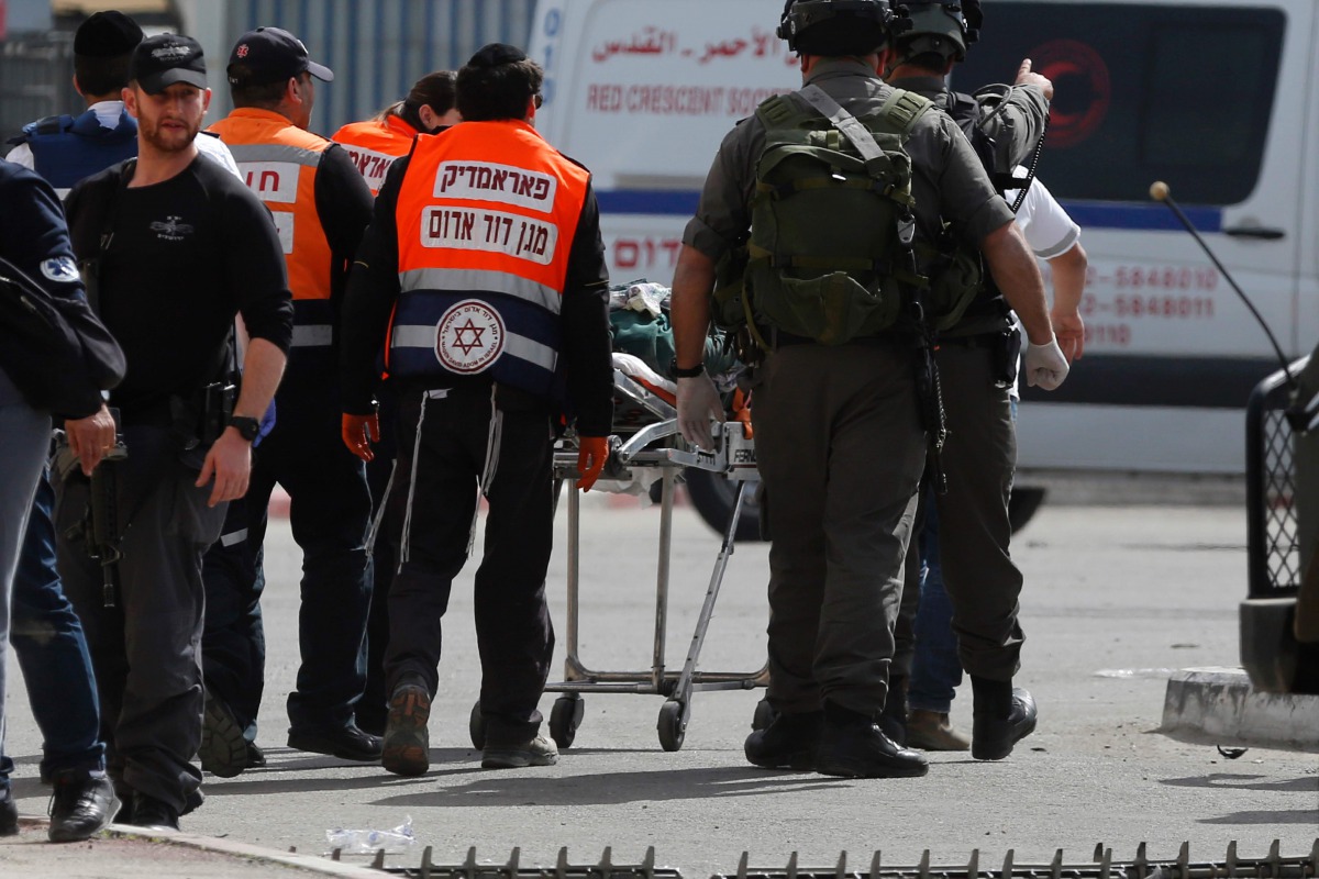 Israelis paramedics transport a Palestinian woman, who was shot and wounded by Israeli security forces upon failing to heed to repeated orders to halt, near the Qalandia checkpoint, between Jerusalem and the occupied West Bank, on February 27, 2017. AFP /