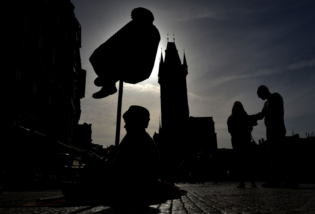 A couple look on the Street performers during a sunny day on April 5 2016 on the Old Town Square in Prague (AFP / Michal Cizek) 