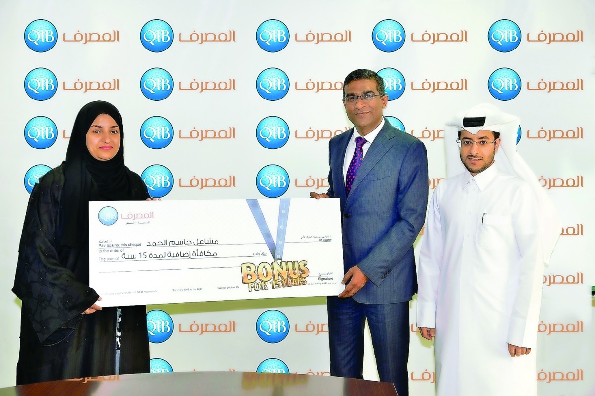 QIB officials handing a 15 years salary bonus for one of its costumers. 