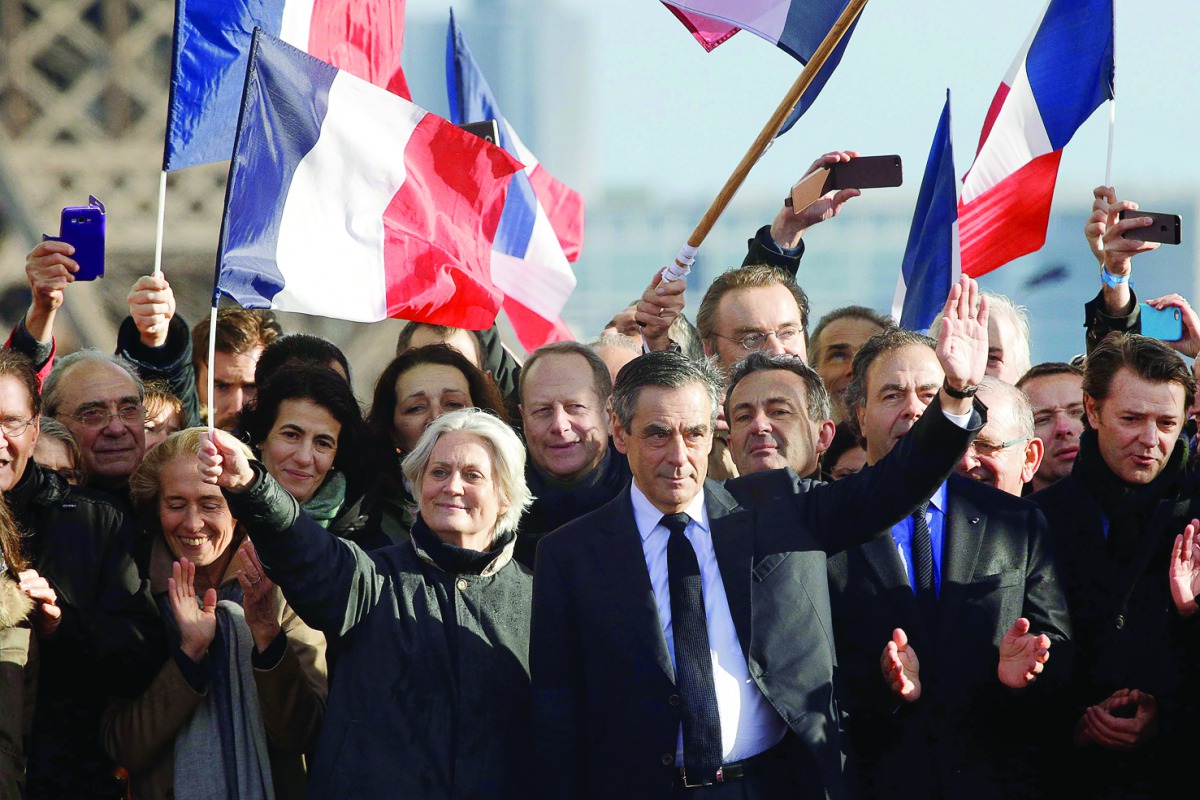 A file photo of French presidential candidate Francois Fillon (centre-right) gesturing at supporters next to his wife Penelope Fillon (centre-left) waving a French flag, during a rally in Paris.