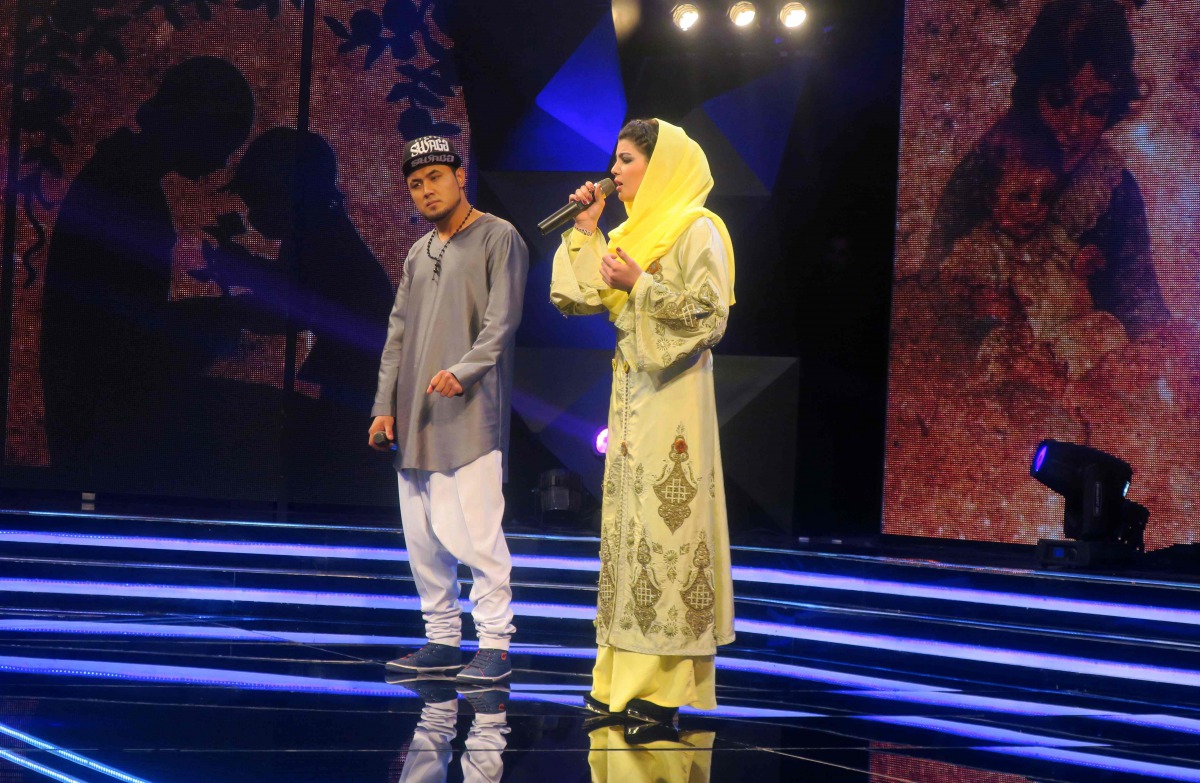 In this photograph taken on March 9, 2017, young Afghan singer Zulala Hashemi (R) stands alongside competitor Sayed Jamal Mubarez as they perform during the television music competition 'Afghan Star' in Kabul. (AFP / Anne CHAON)
