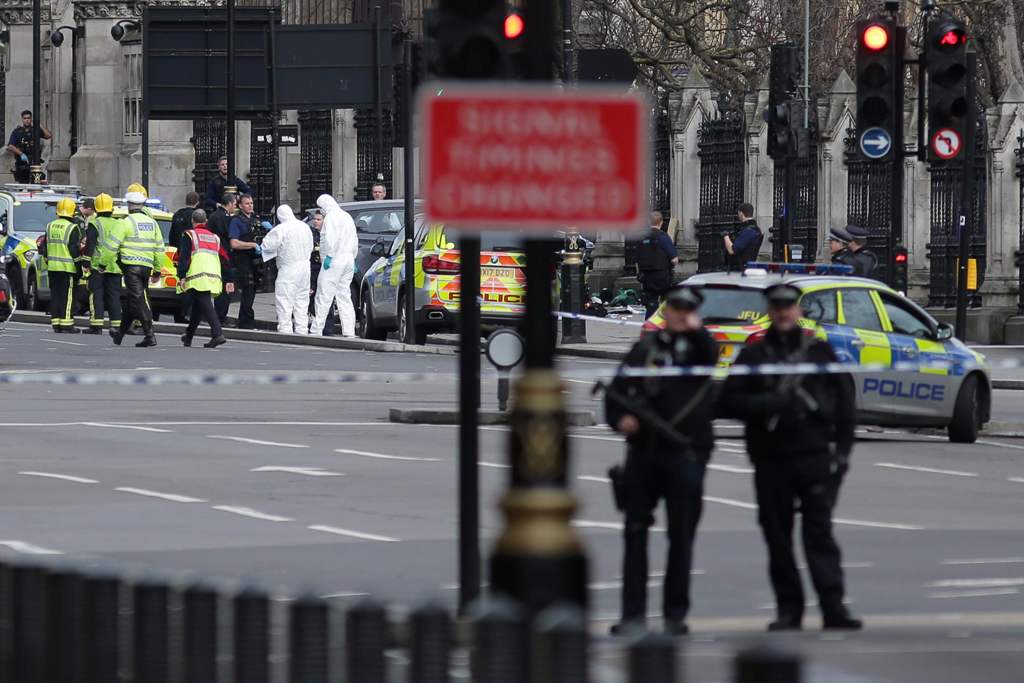 Armed police officers carry their weapons as forensics officers work near a grey vehicle that crashed into the railings of the Houses of Parliament in central London on March 22, 2017, during an emergency incident. AFP / Daniel LEAL-OLIVAS
