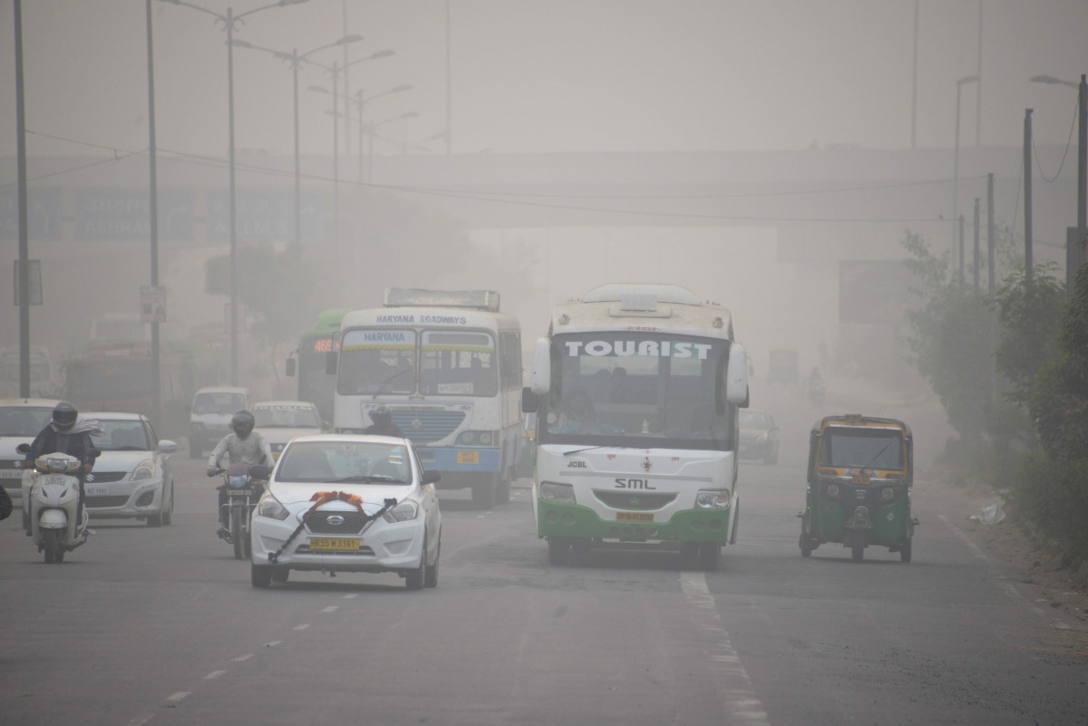 In this photograph taken on November 7, 2016 Indian commuters journey along a major road as heavy smog covers in New Delhi (AFP) 