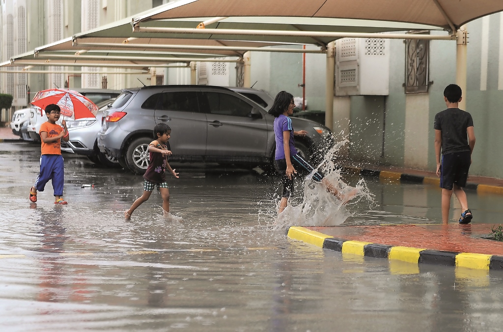 Children frolic in rain water at Ezdan Village Al Wukair, yesterday. Pic: Abdul Basit / The Peninsula