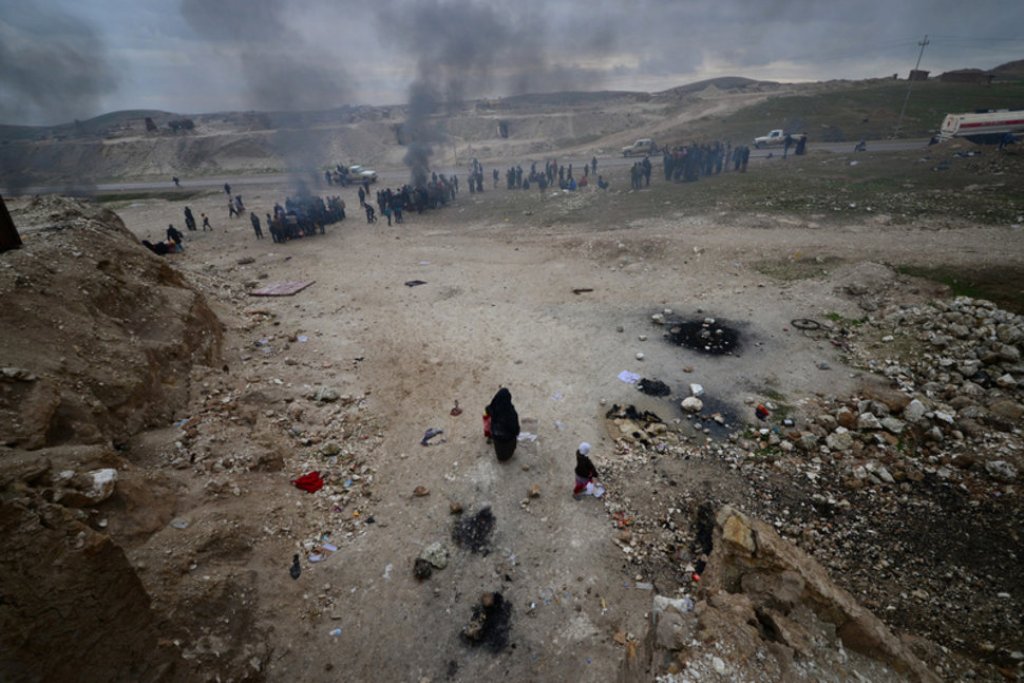 Displaced Iraqis, who fled their homes, warm themselves during a battle between Iraqi forces and Islamic State militants, near Badush, Iraq. REUTERS/Stringer REUTERS.