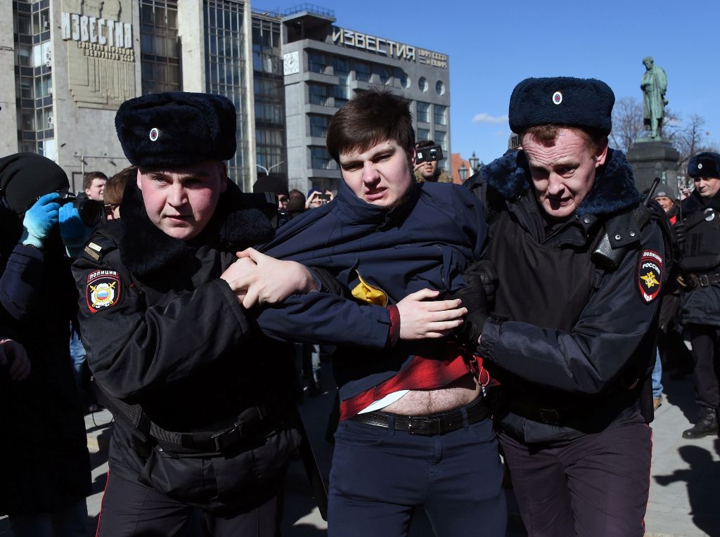 Police officers detain a man as opposition supporters gather for an unauthorised anti-corruption rally in central Moscow on March 26, 2017.   AFP / Vasily MAXIMOV
