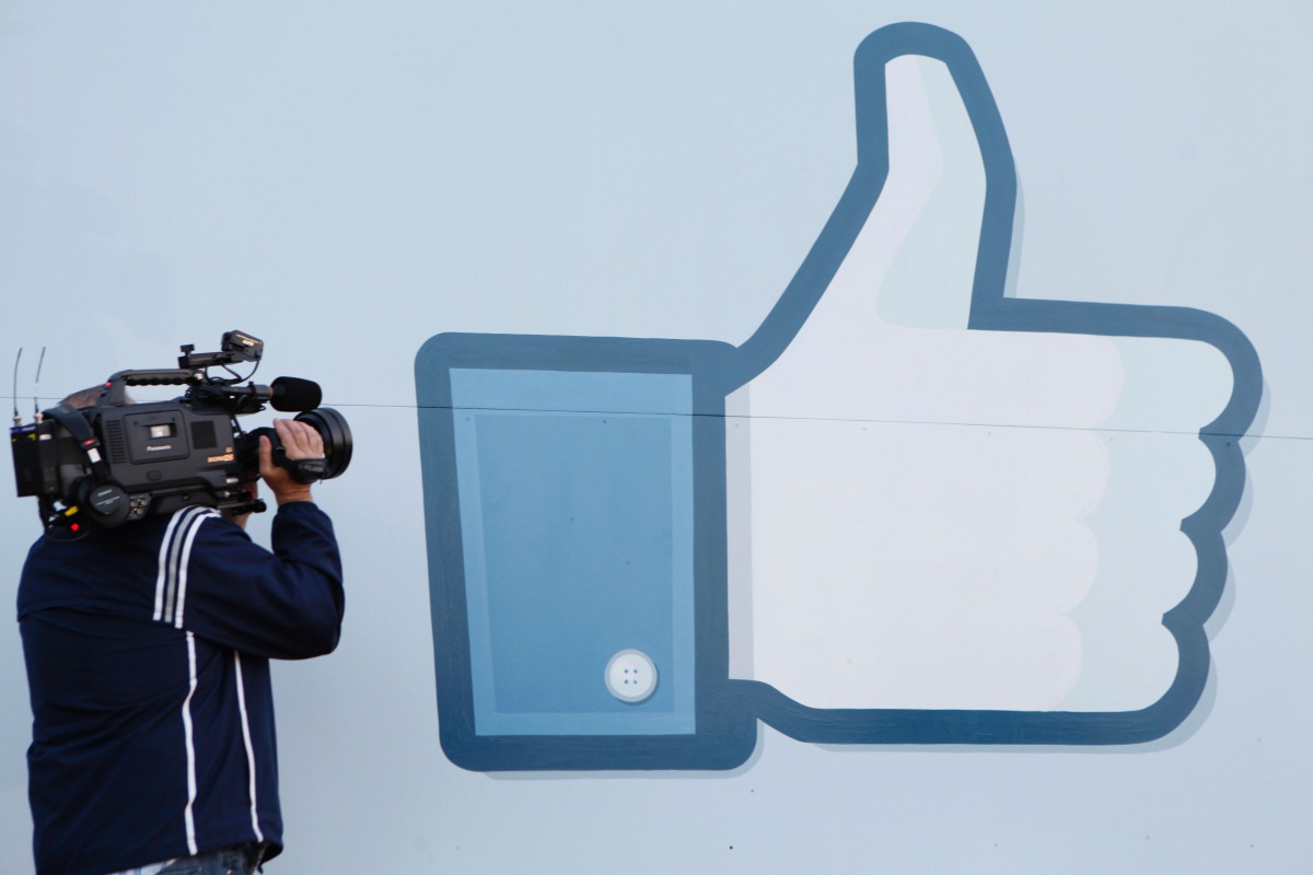 A videographer shooting the side of Facebook Like Button logo displayed at the entrance of the Facebook Headquarters in Menlo Park, California May 18, 2012 (AFP) 