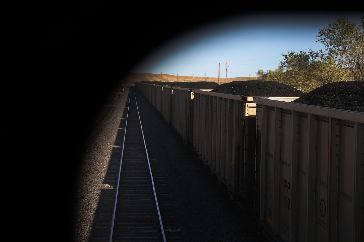 Train cars loaded with coal pass Amtrak's California Zephyr as it rolls along the tracks during its daily 2,438-mile trip to Emeryville/San Francisco from Chicago that takes roughly 52 hours on March 24, 2017 in Green River, United States. President Trump