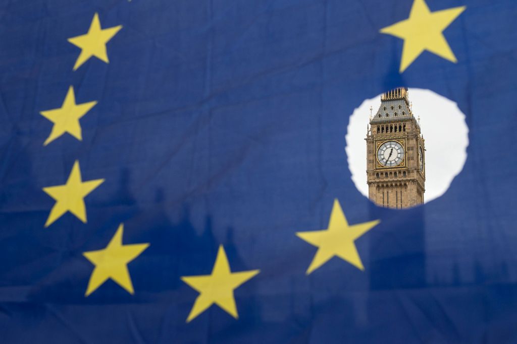 A pro-remain protester holds up an EU flag with one of the stars symbolically cut out in front of the Houses of Parliament shortly after British Prime Minister Theresa May announced to the House of Commons that Article 50 had been triggered in London on M