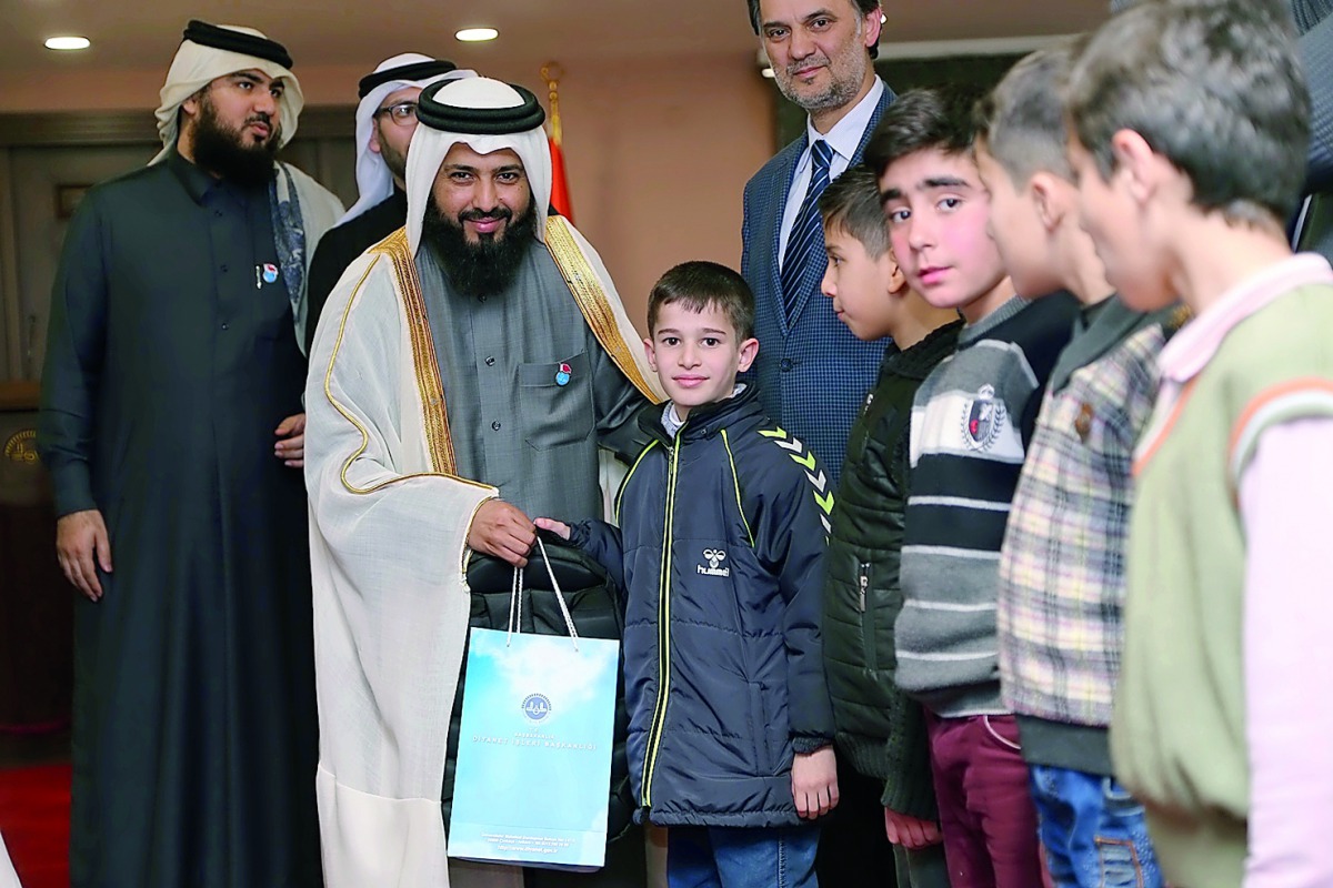 Dr Ayed bin Dabssan Al Qahtani, Chairman, Board of Trustees and General Director, RAF, handing over a bag of textbooks to a Syrian child in Turkey.